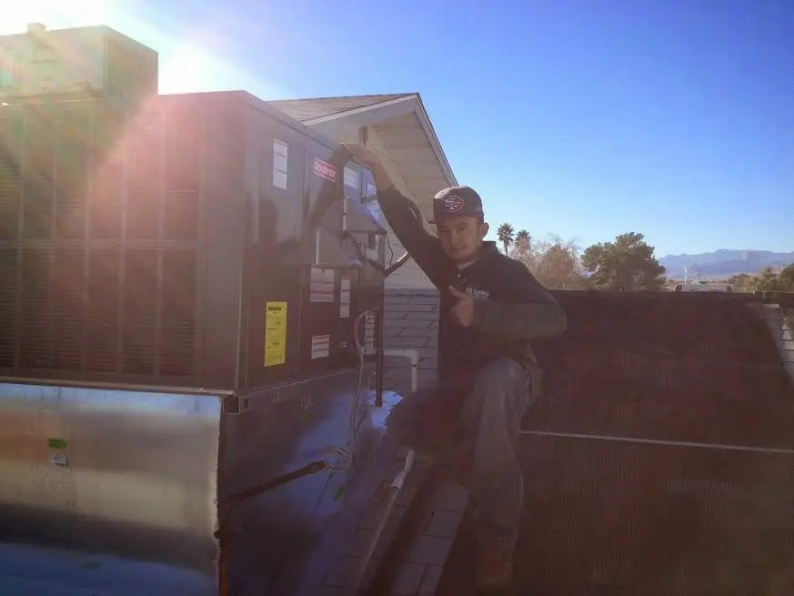 HVAC technician performing Heat Pump Repair on a rooftop unit in Tomball